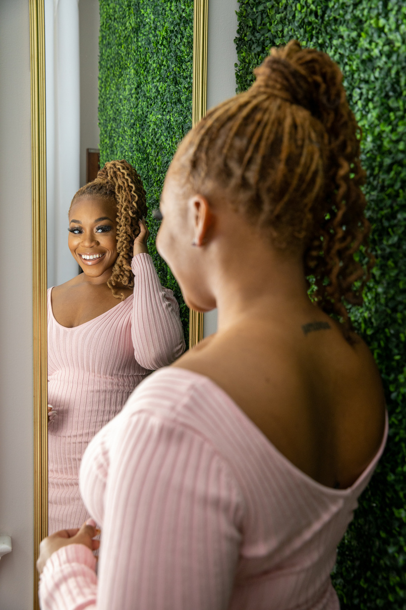 Smiling Woman in Dreadlocks Wearing Dress Looking at the Mirror